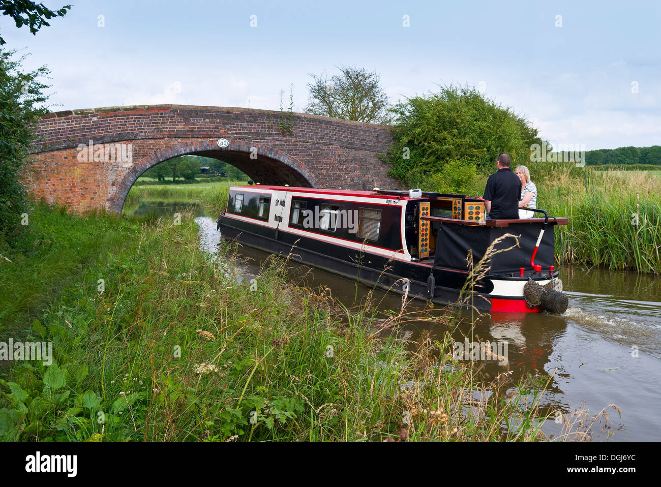 Ein paar genießt einen schönen Tag auf einem Narrowboat auf den Ashby Kanal. Stockfoto