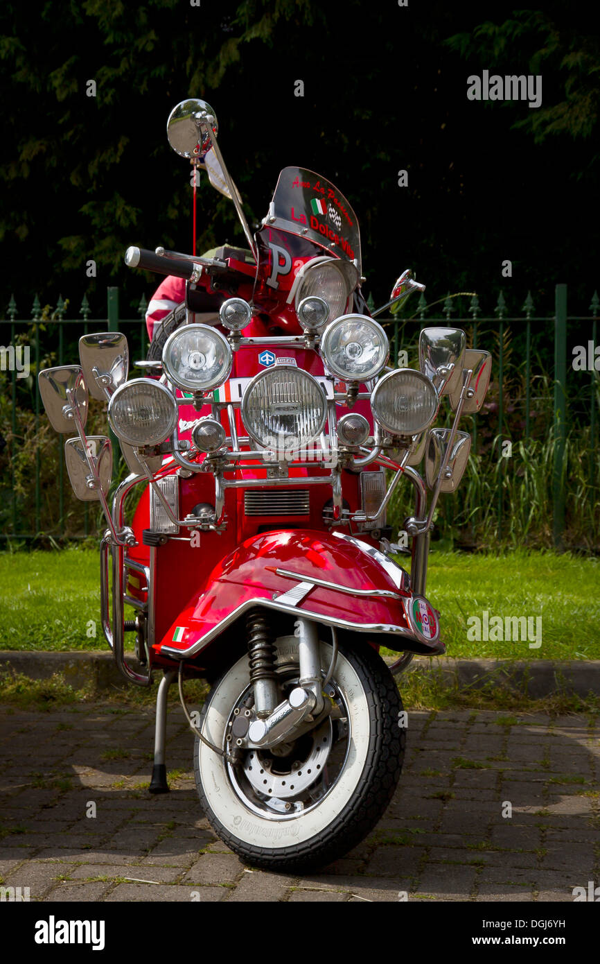 Ein roter Roller mit vielen Lampen und Spiegel im Stil eines mod Roller aus  den 60er Jahren Stockfotografie - Alamy