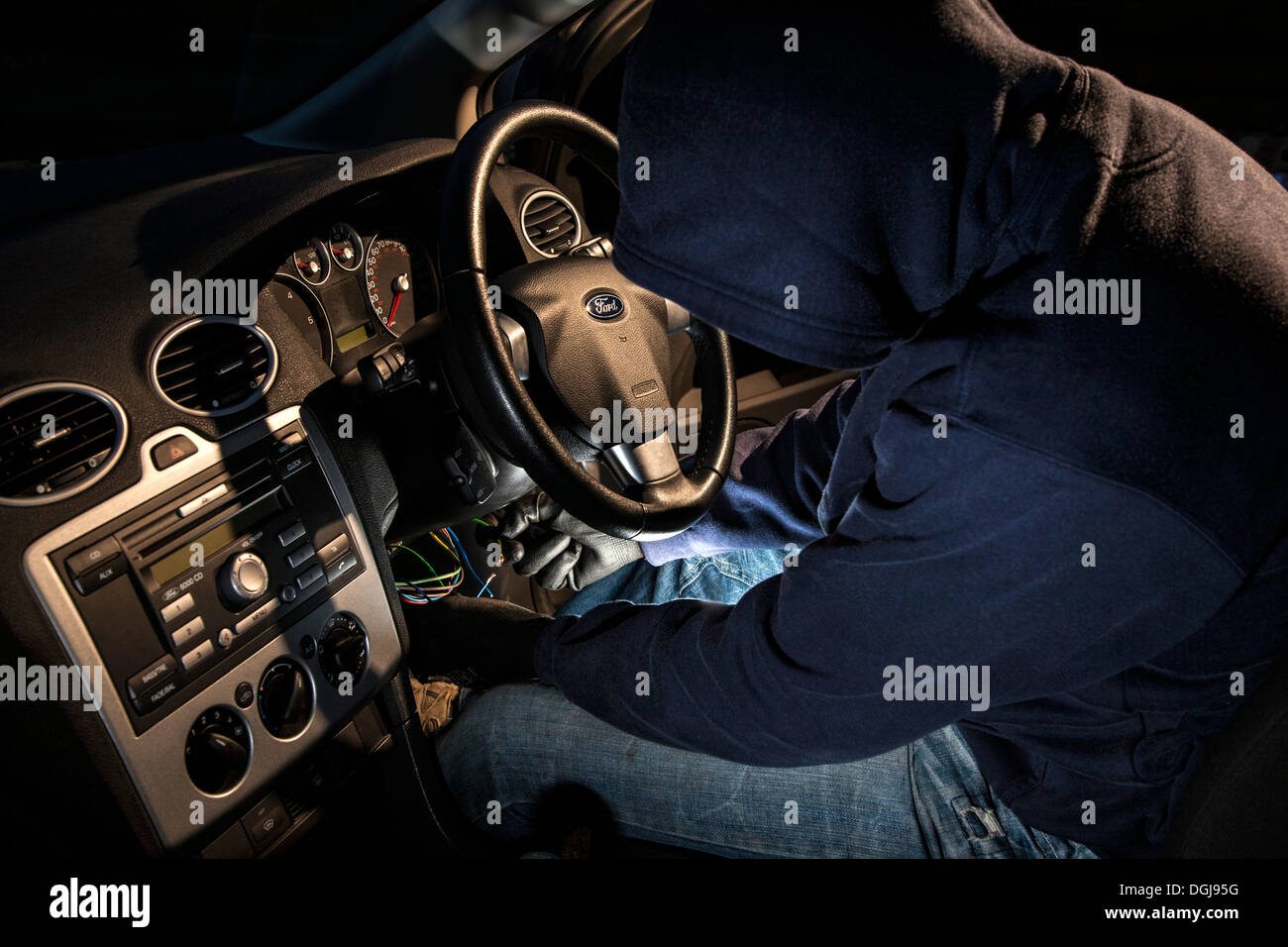 Ein Mann trägt einen hoody heißen Verdrahtung eines Autos. Stockfoto