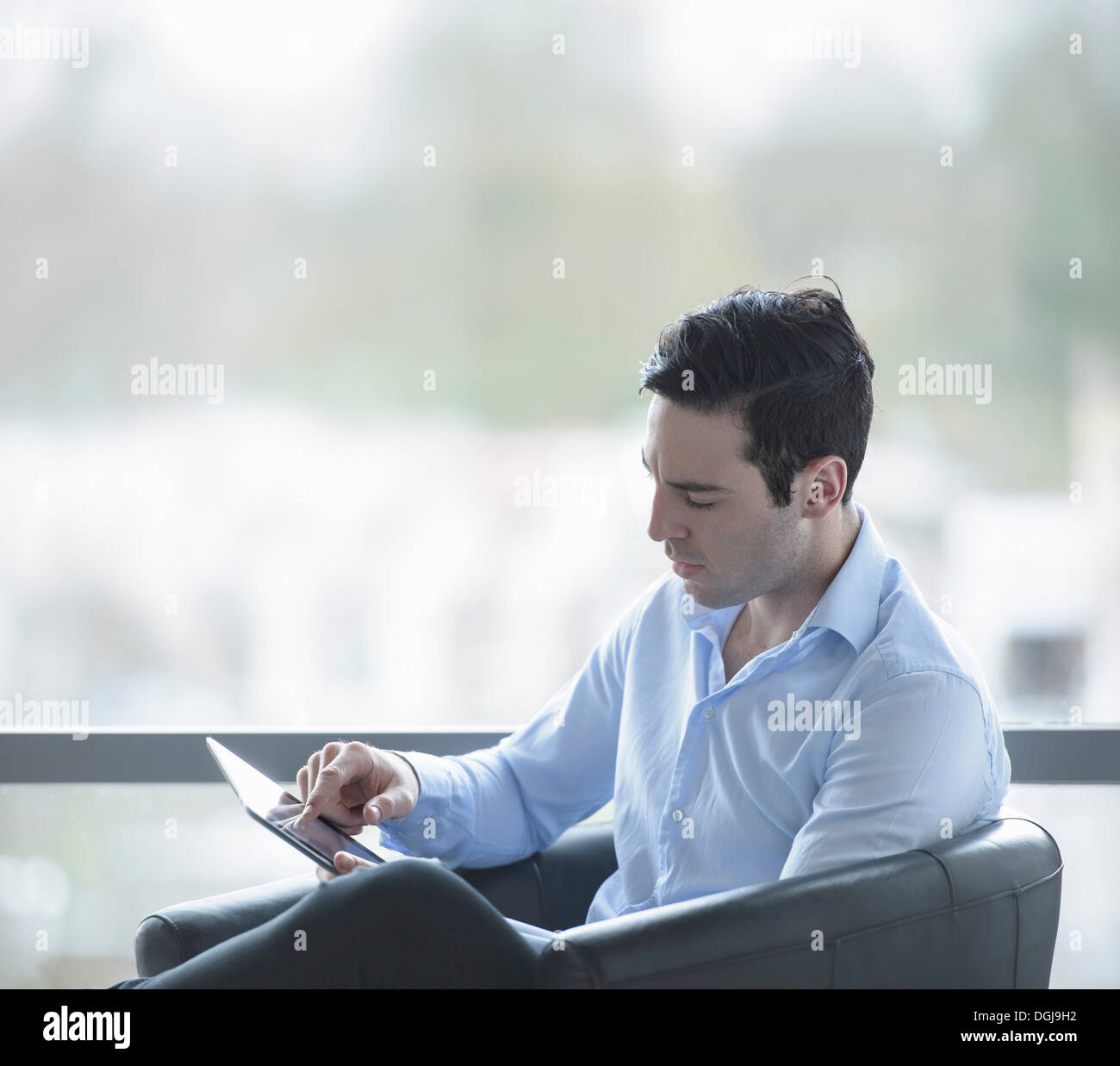 Geschäftsmann mit digital-Tablette von Bürofenster Stockfoto