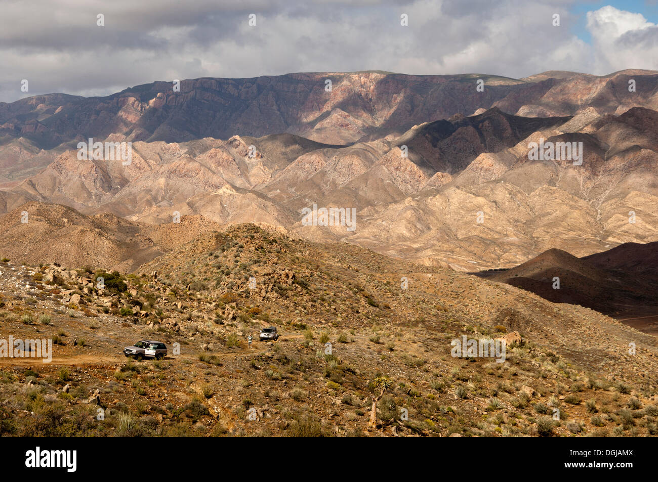 Breite hügelige Landschaft mit zwei Geländewagen, Richtersveld Nationalpark, Northern Cape, Südafrika Stockfoto