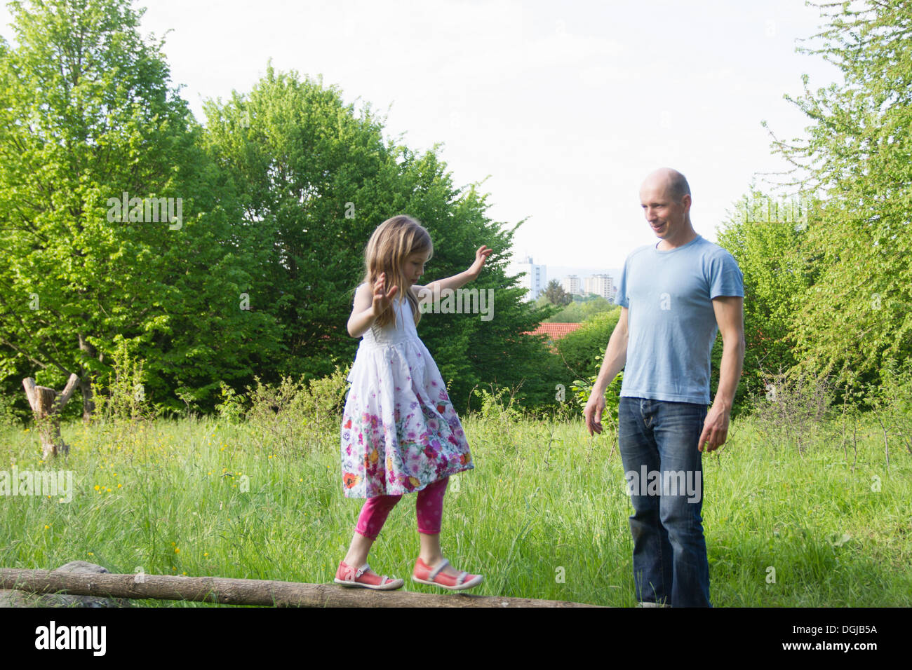 Uhren-Tochter Vaters balancieren auf Baumstamm Stockfoto