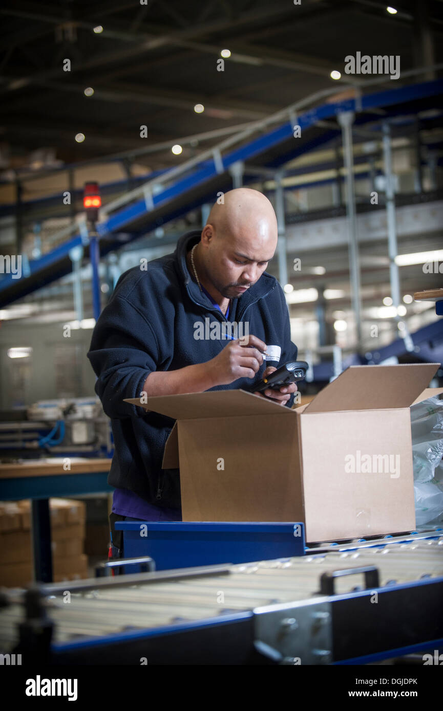 Männliche Lagerarbeiter mit Barcode-scanner Stockfoto