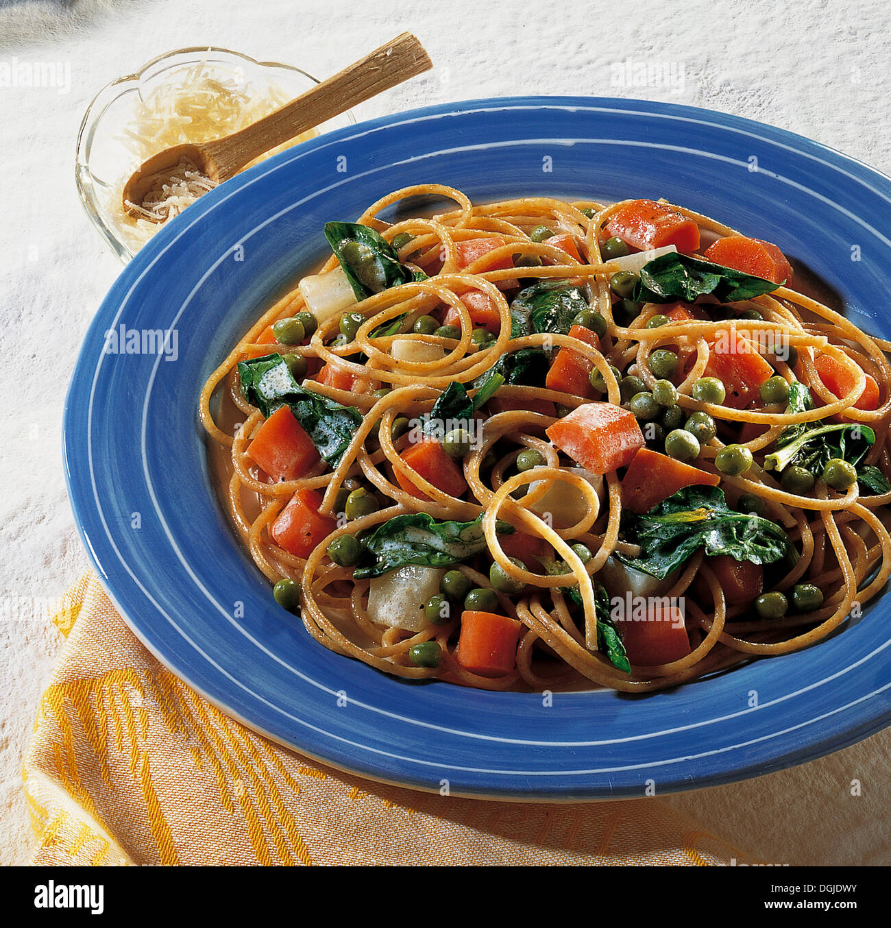 Vollkorn Spaghetti mit Frühlingsgemüse, gefrorene Erbsen, Spinat, Kohlrabi, Karotten und saure Sahne, Vollwert-Küche Stockfoto