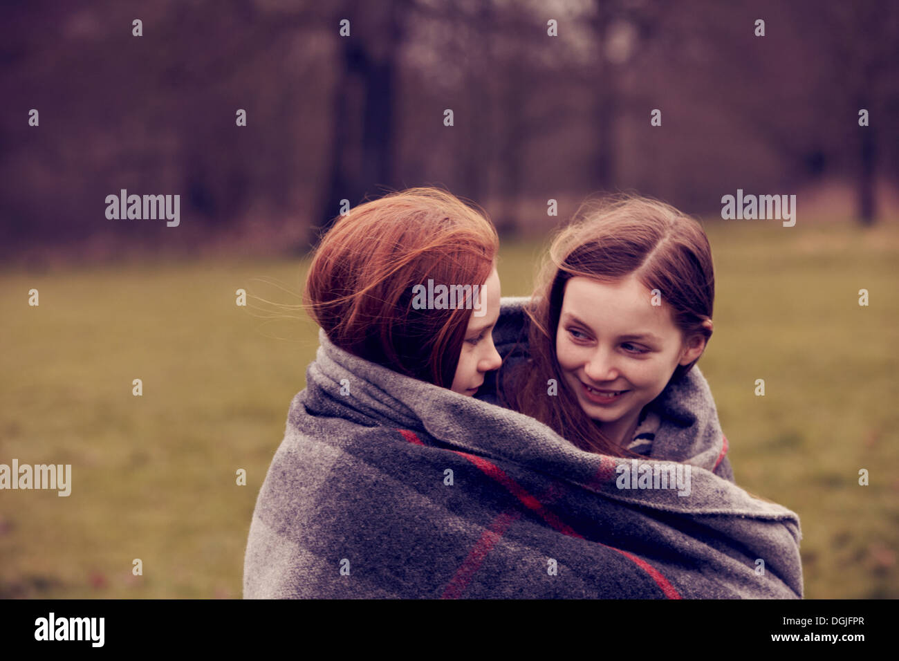 Mädchen, eingewickelt in eine Decke im Freien, Lächeln Stockfoto