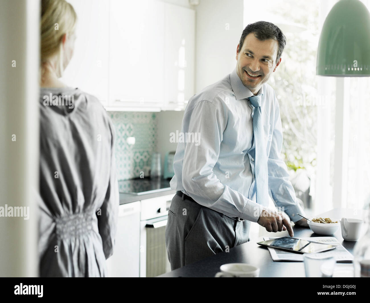 Reife Geschäftsmann mit Tablet und lächelnd in Küche Stockfoto
