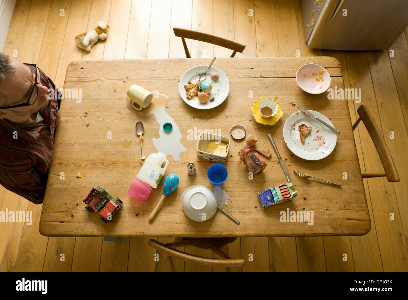 Draufsicht des reifen Mannes allein chaotisch Frühstückstisch sitzen Stockfoto