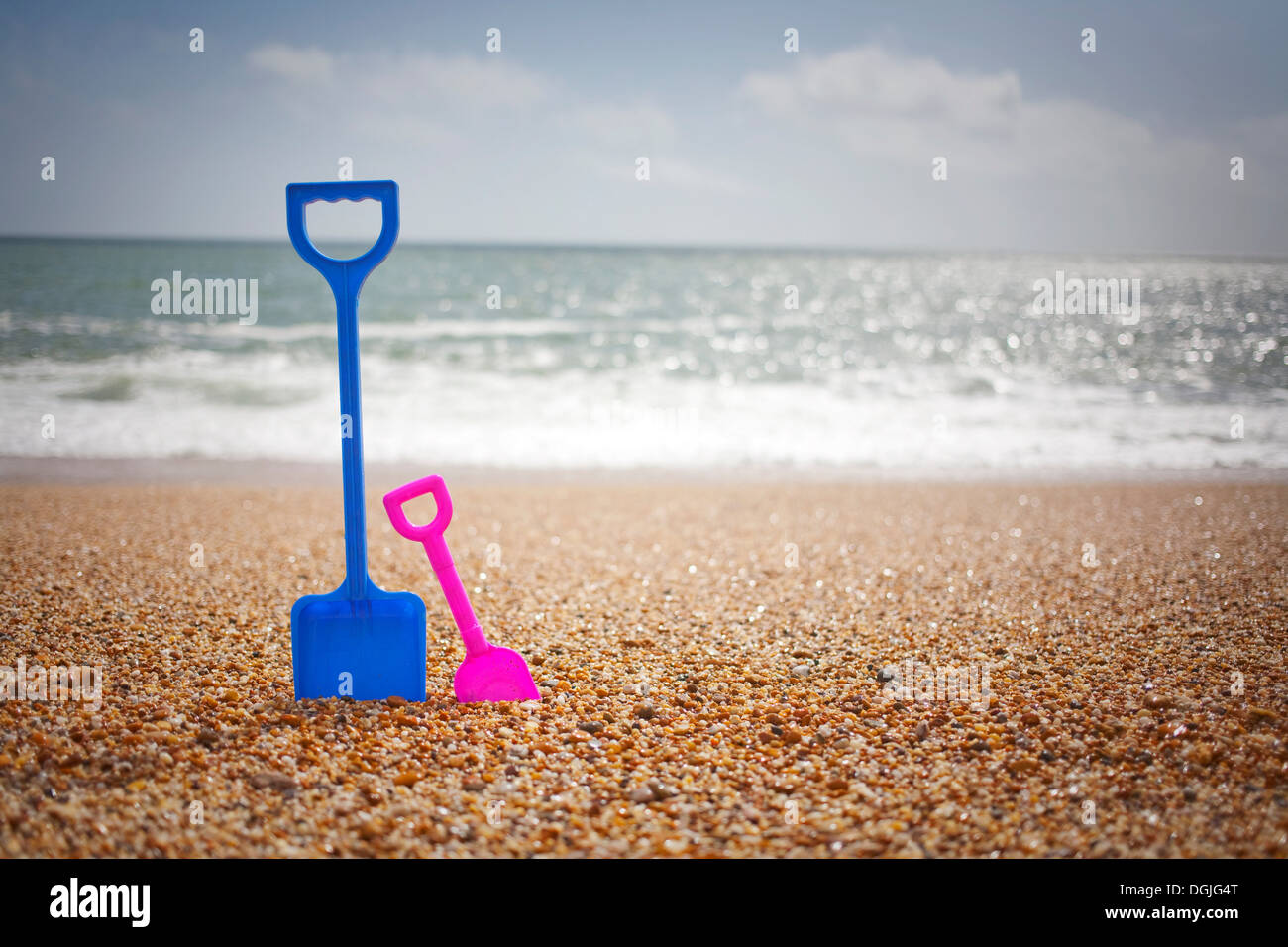 Blau und rosa Spaten stehen im Sand am Strand Stockfoto