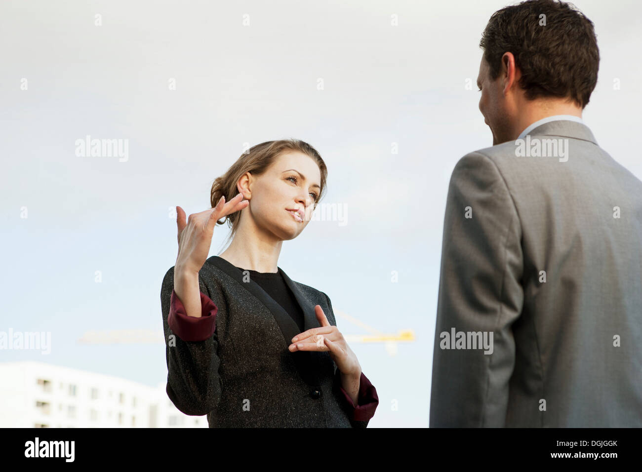 Mitte adult Geschäftsfrau im Gespräch mit Kollegen im freien Stockfoto