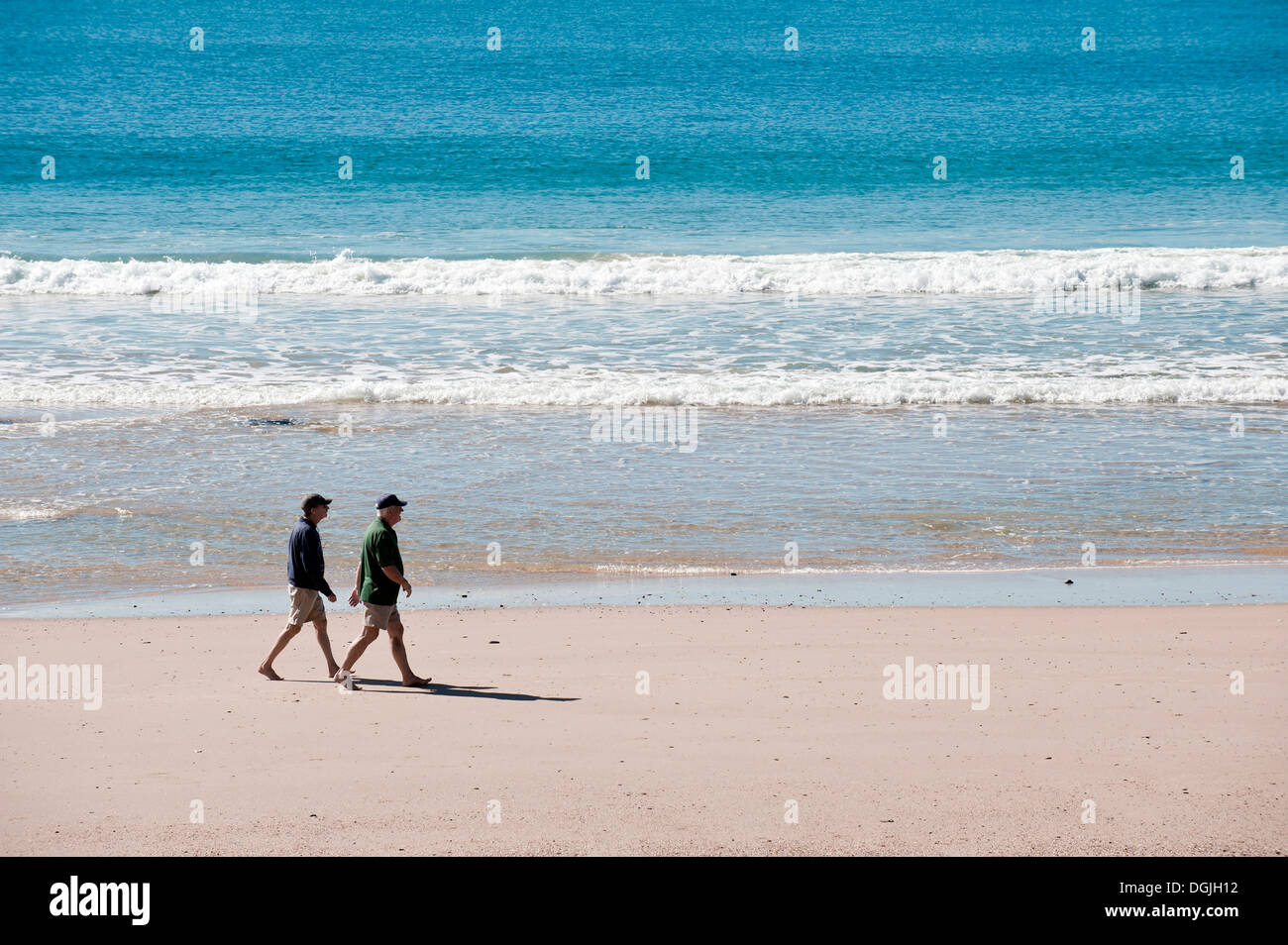 Zwei Männer gehen in Mooloolaba Beach an der Sunshine Coast. Stockfoto