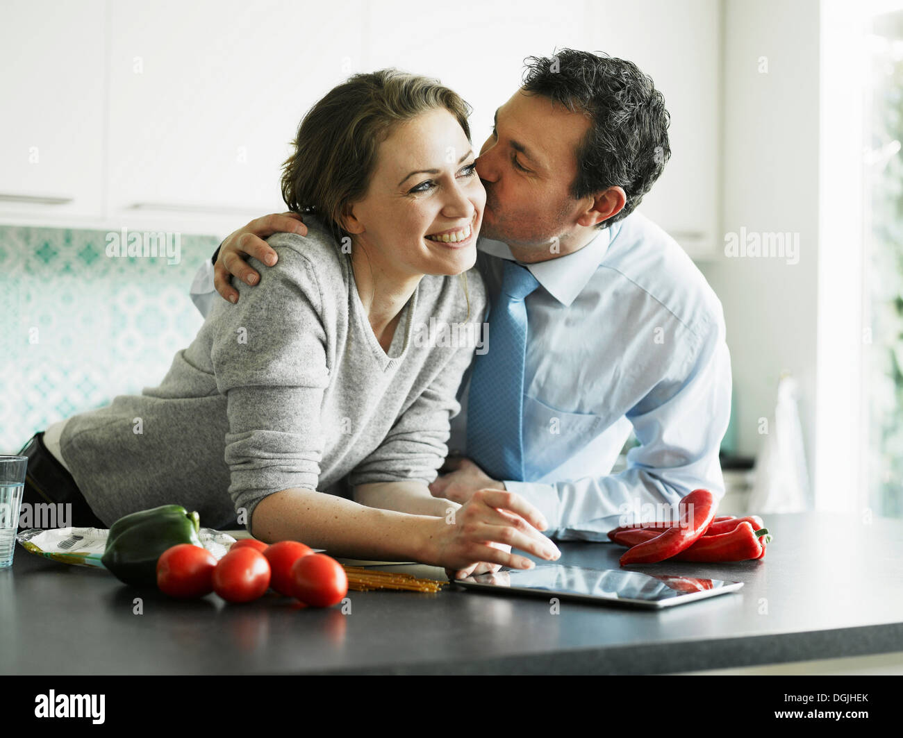 Küssende Frau Kaufmann in Küche Stockfoto