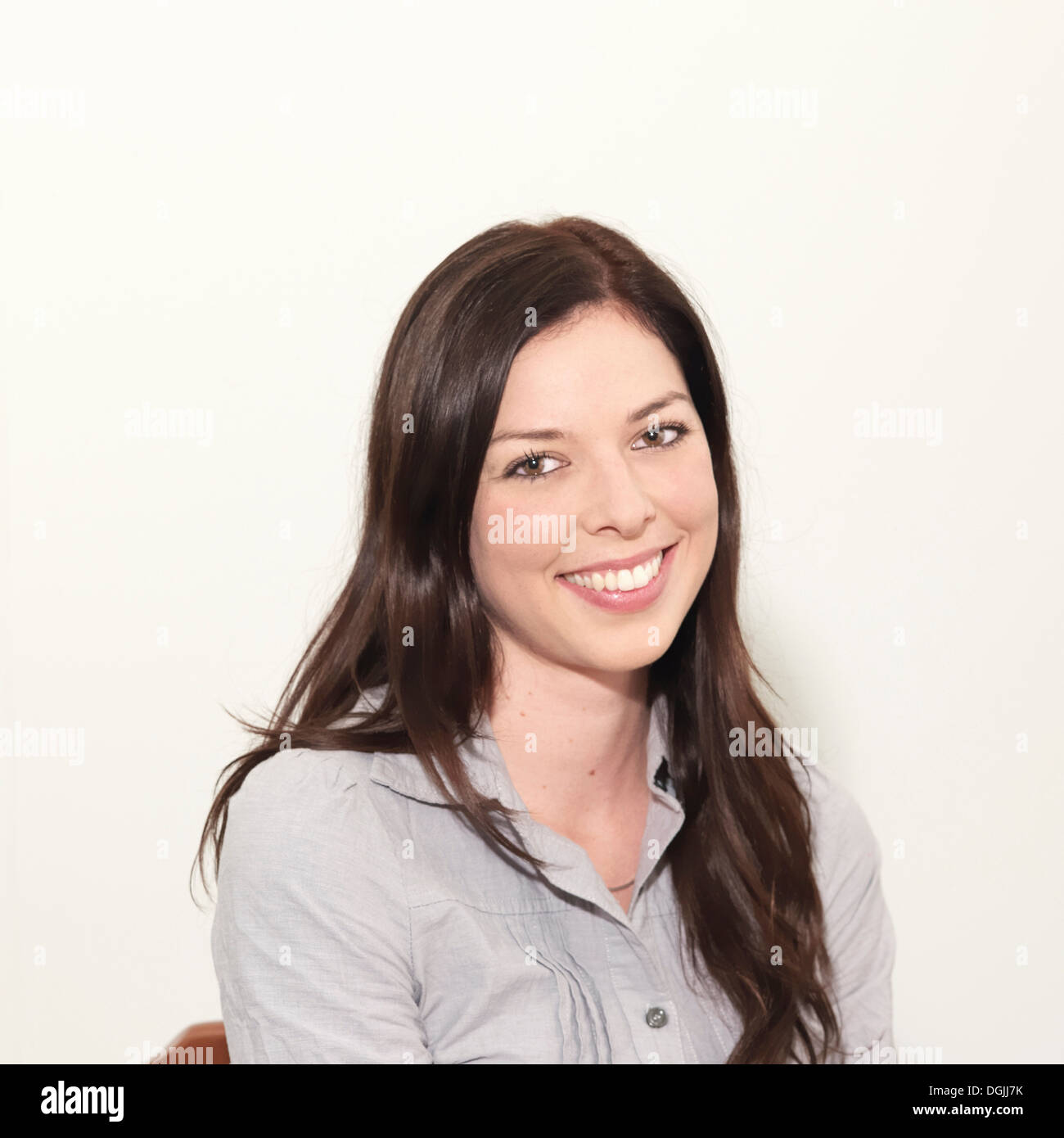 Porträt der jungen Frau lächelnd vor weißem Hintergrund Stockfoto