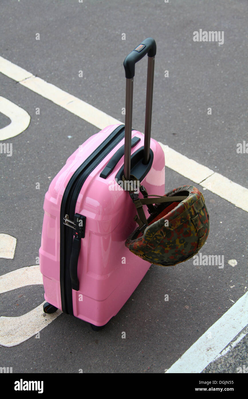 Rosa Koffer mit einem Kampf Helm der Bundeswehr Stockfoto