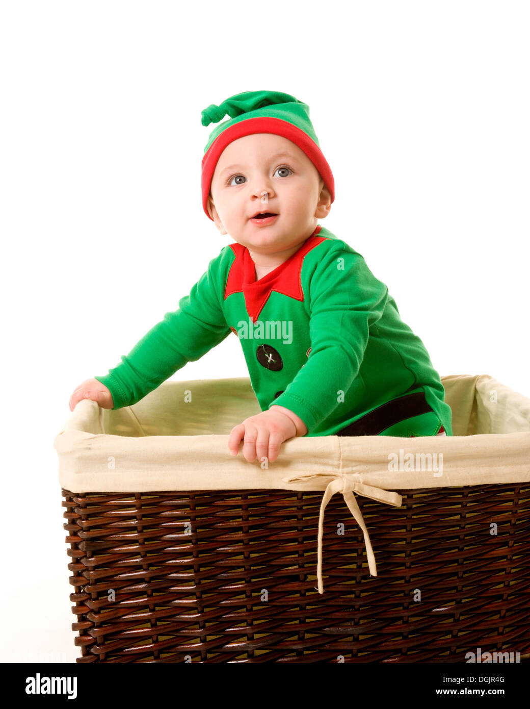 Kind als Weihnachtself im Korb gekleidet Stockfoto