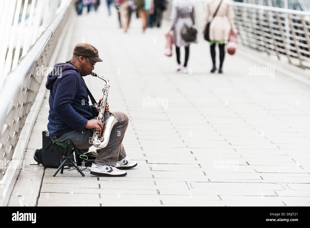 Ein Saxophonist als Straßenmusikant auf Hungerford Bridge in London. Stockfoto