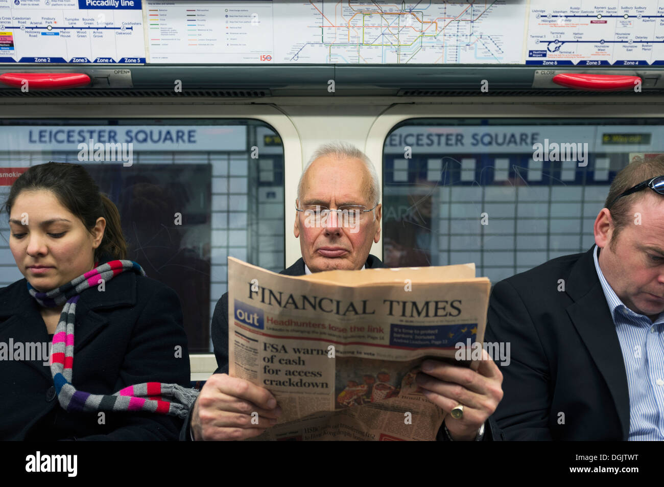 Ein Geschäftsmann, der Financial Times in einem U-Bahn-Zug zu lesen. Stockfoto