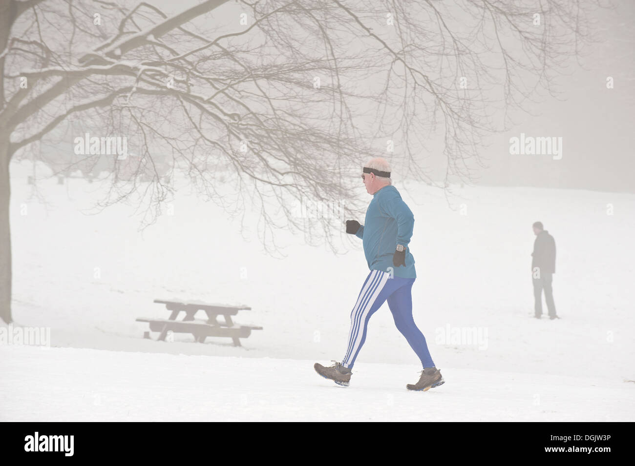 Ein Mann mittleren Alters durch Einfrieren, Nebel und Schnee Joggen. Stockfoto