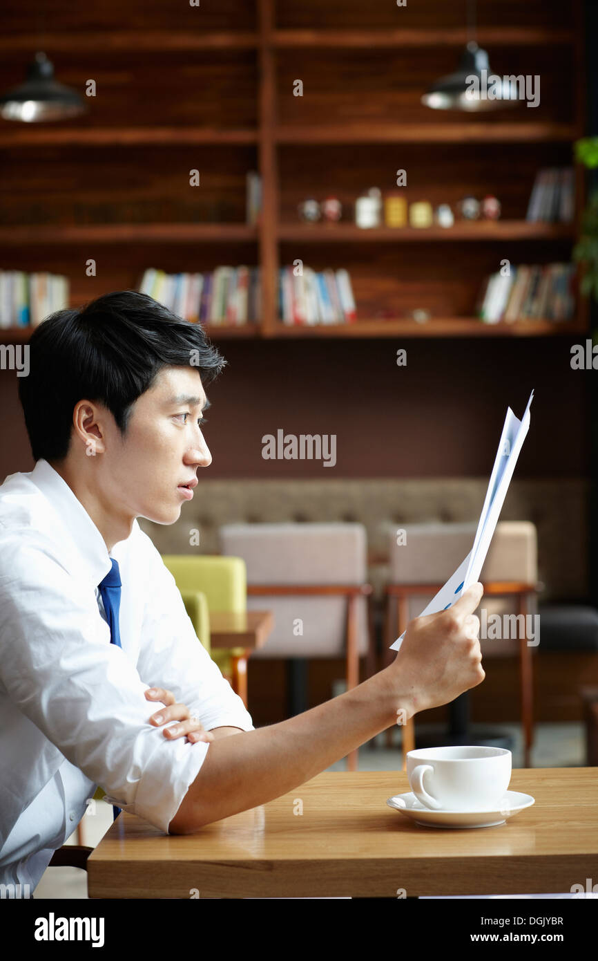 ein Business-Mann sitzt an einem Kaffee-Tisch Stockfoto