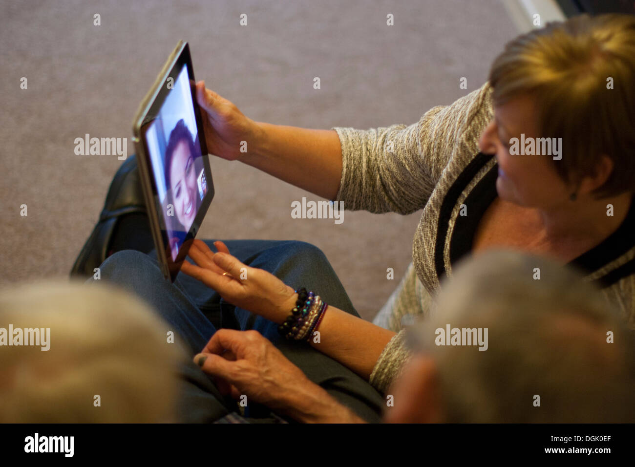Skype-Videoanruf läuft auf einem Apple iPad – Nutzer kommunizieren über die Skype-App, wobei mobile Videokonferenzen auf Tablet-Geräten, Großbritannien, hervorgehoben werden. Stockfoto