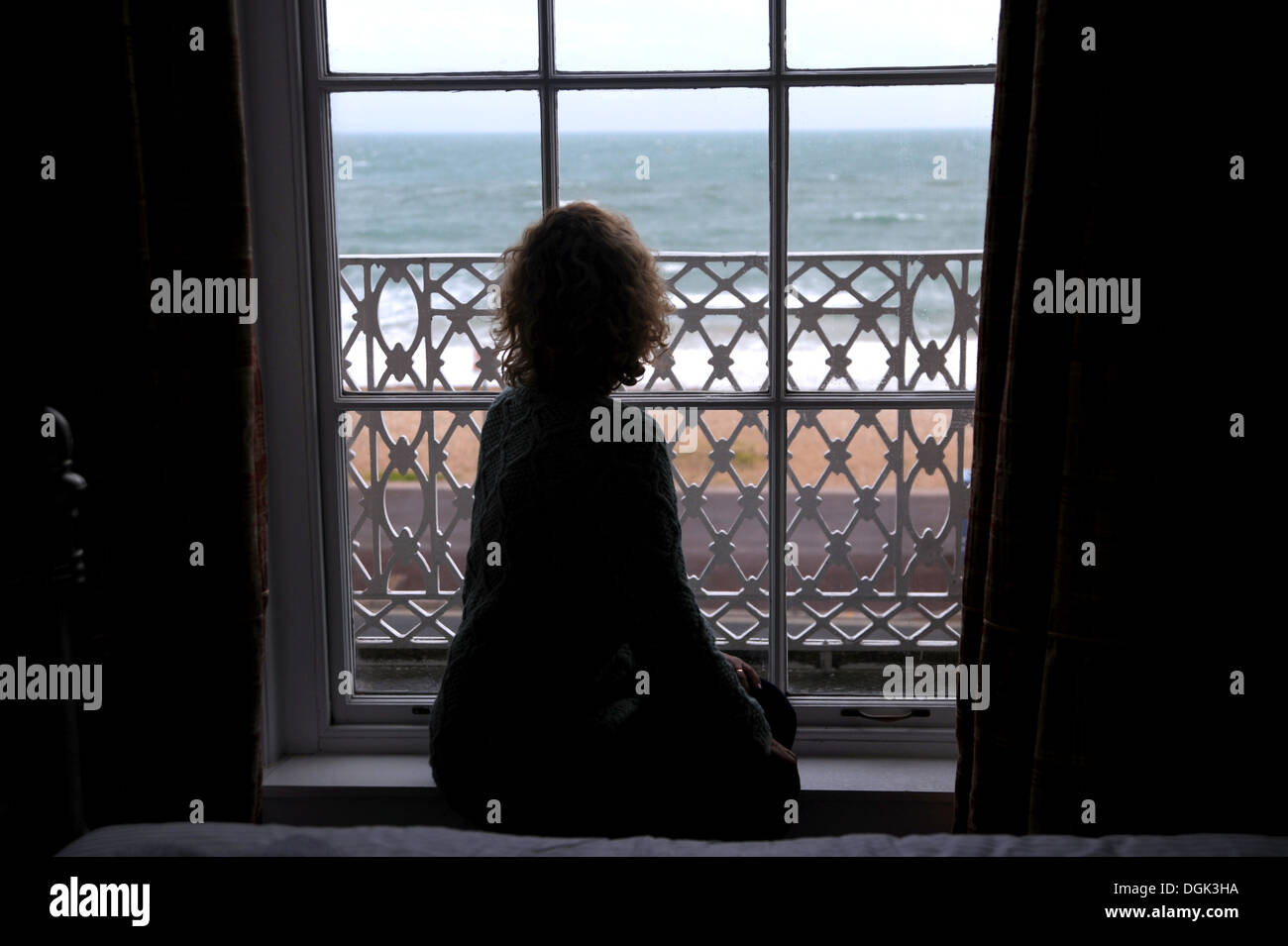 Frau allein einsam Blick aus dem Schlafzimmerfenster traurig Stockfoto
