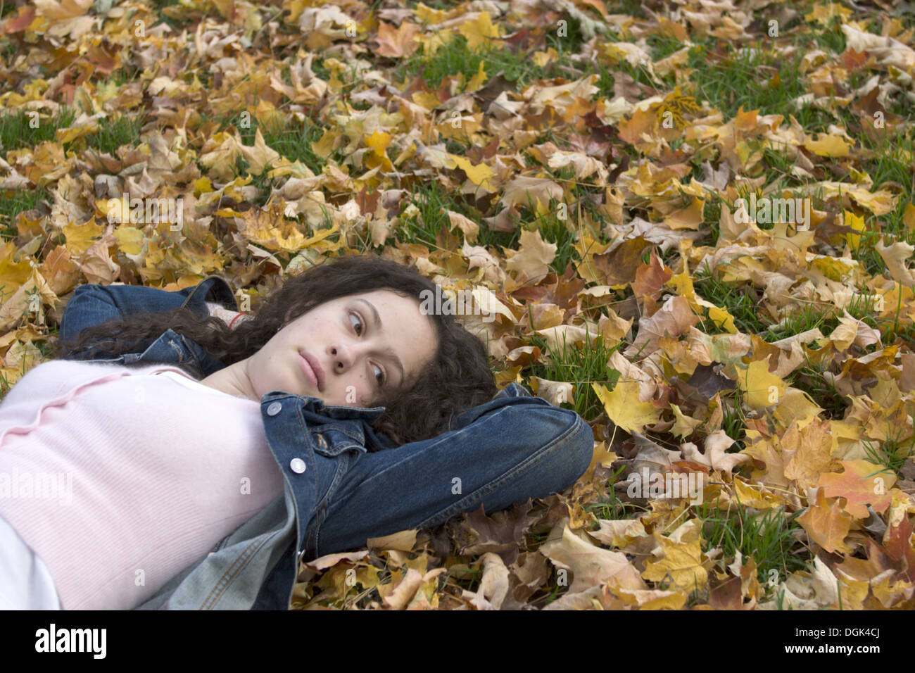 Teenager-Mädchen liegend in das Herbstlaub im Prospect Park, Brooklyn, NY. Stockfoto