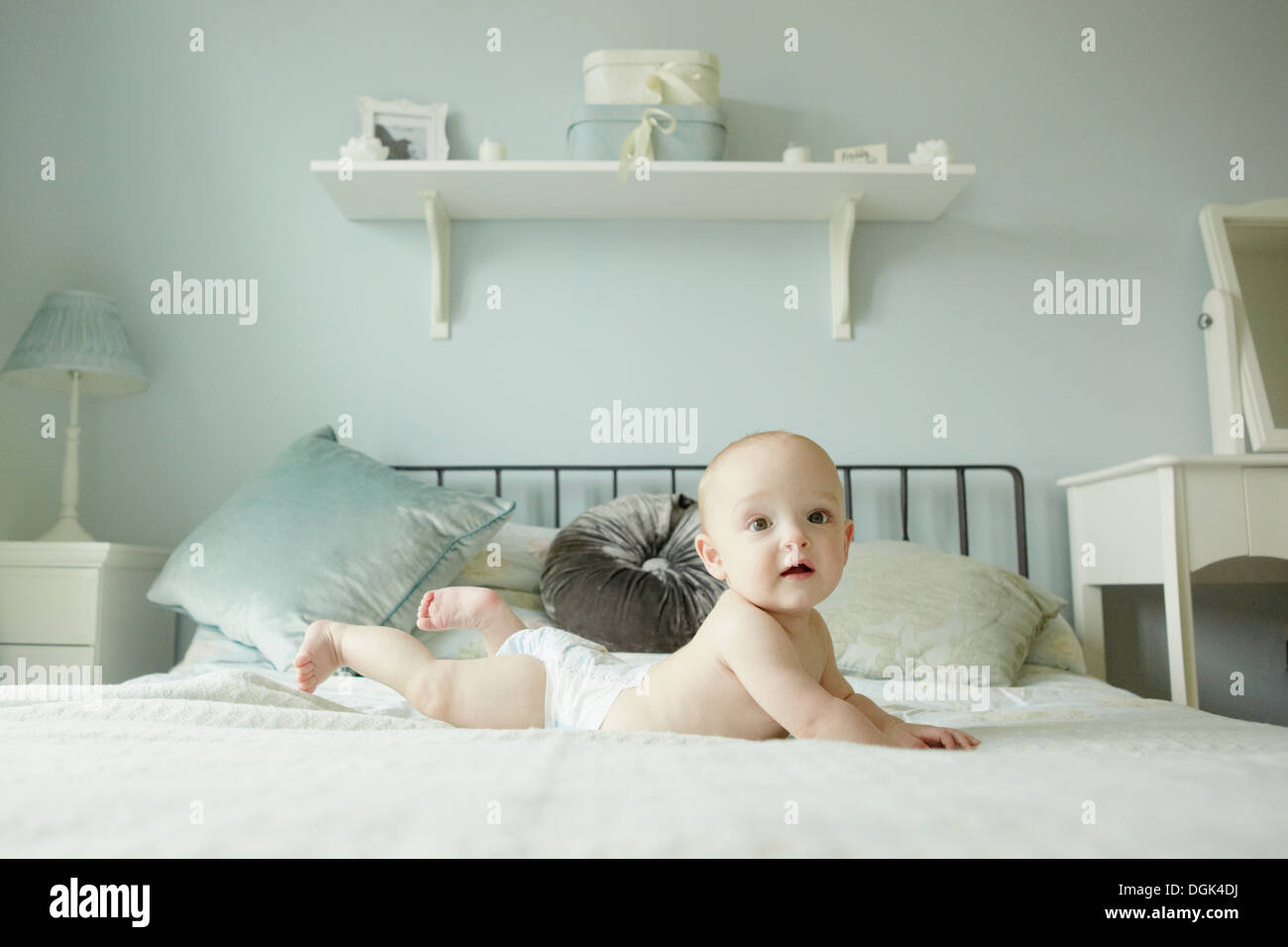 Baby Boy auf Vorderseite auf Bett liegend Stockfoto