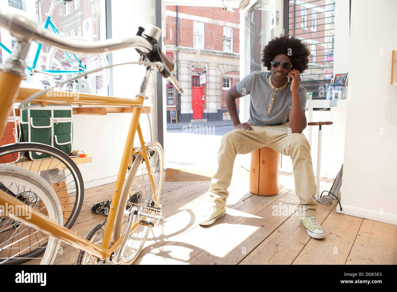 Reifer Mann auf Handy im Fahrradgeschäft Stockfoto