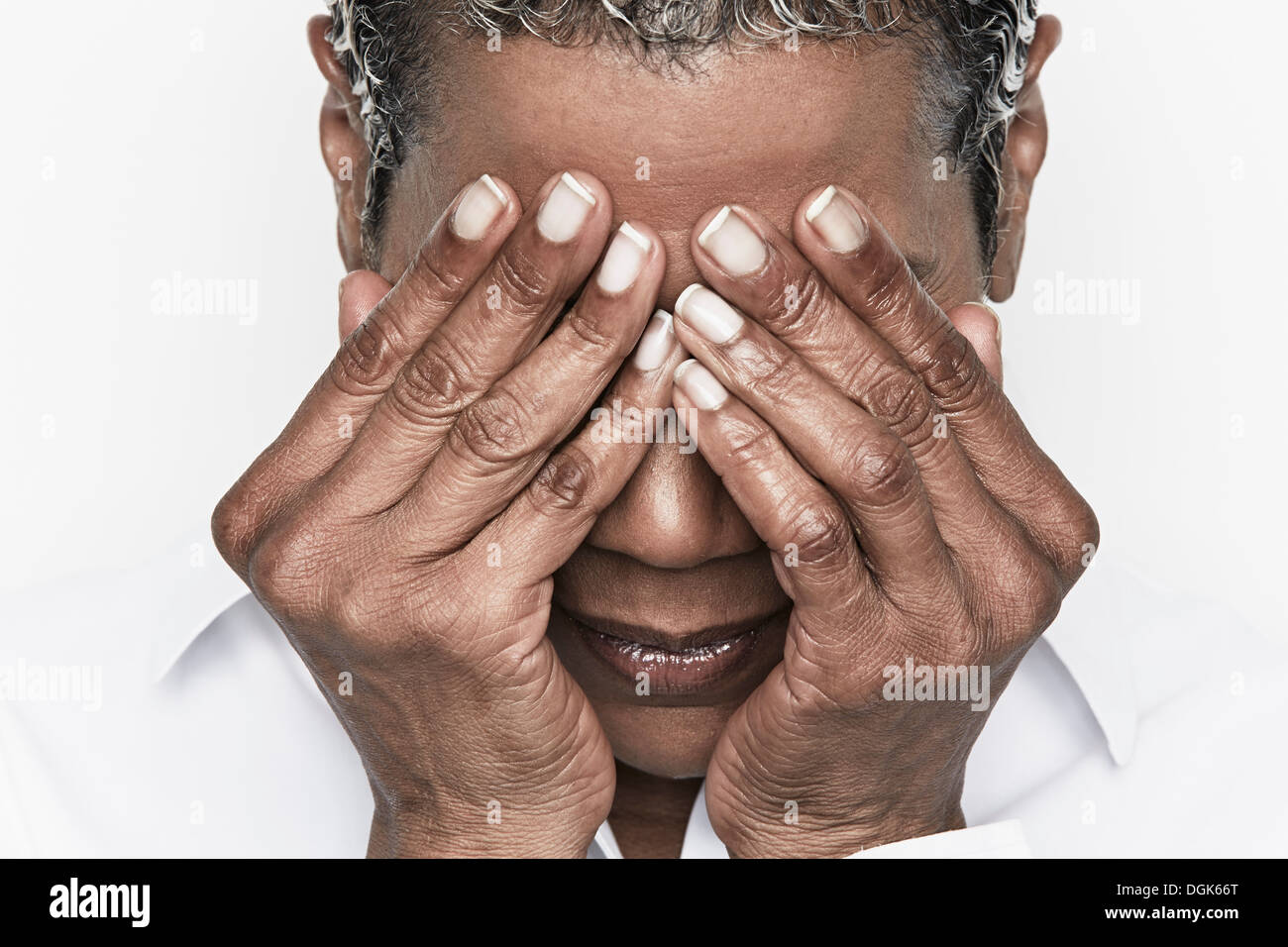 Ältere Frau, die ihre Augen bedecken Stockfoto