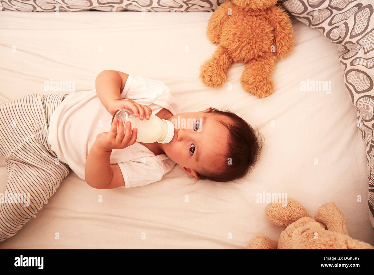 Baby Junge liegend in Krippe Baby Trinkflasche Stockfoto