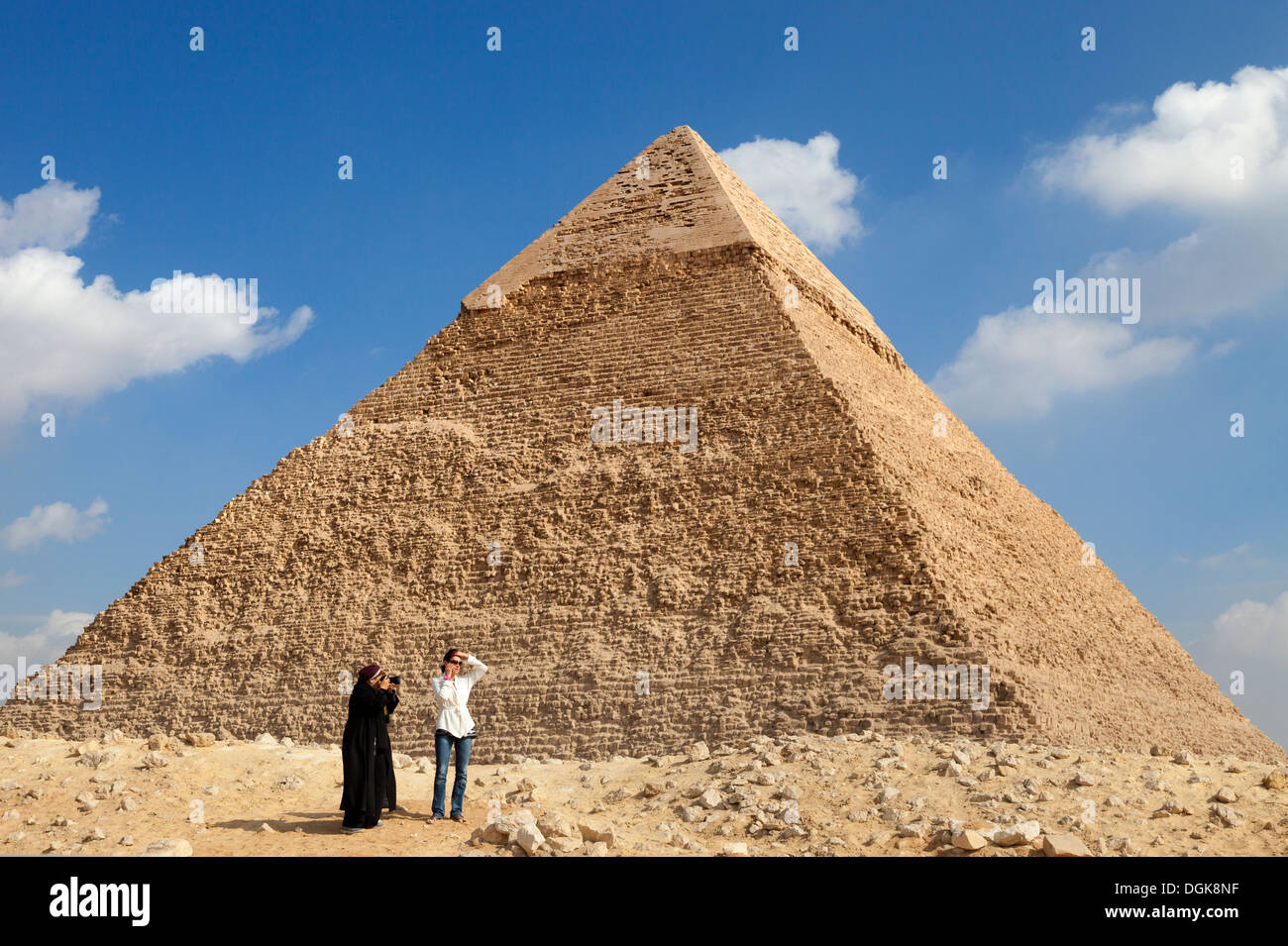Eine ägyptische Frau fotografiert ein Tourist bei der Chephren-Pyramide in Gizeh. Stockfoto