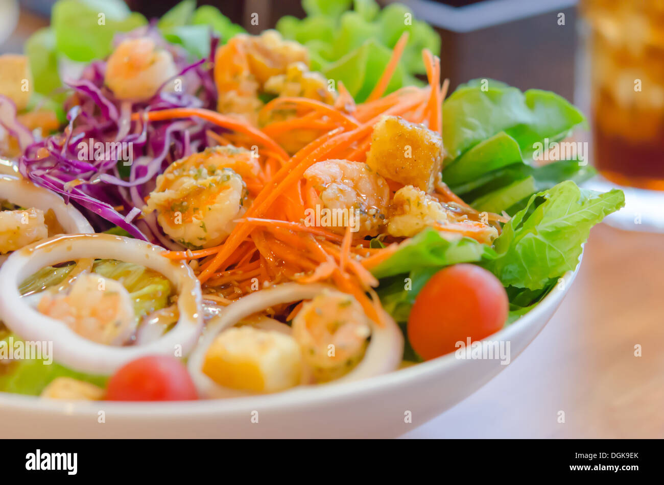 Nahaufnahme von Garnelen und Gemüsesalat mit Sauce in Schüssel weiß Stockfoto