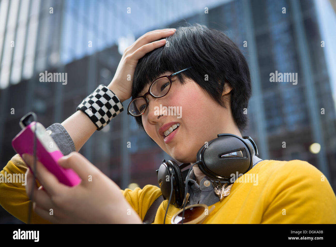 Junge Frau mit MP3-Player mit Händen in Haar Stockfoto