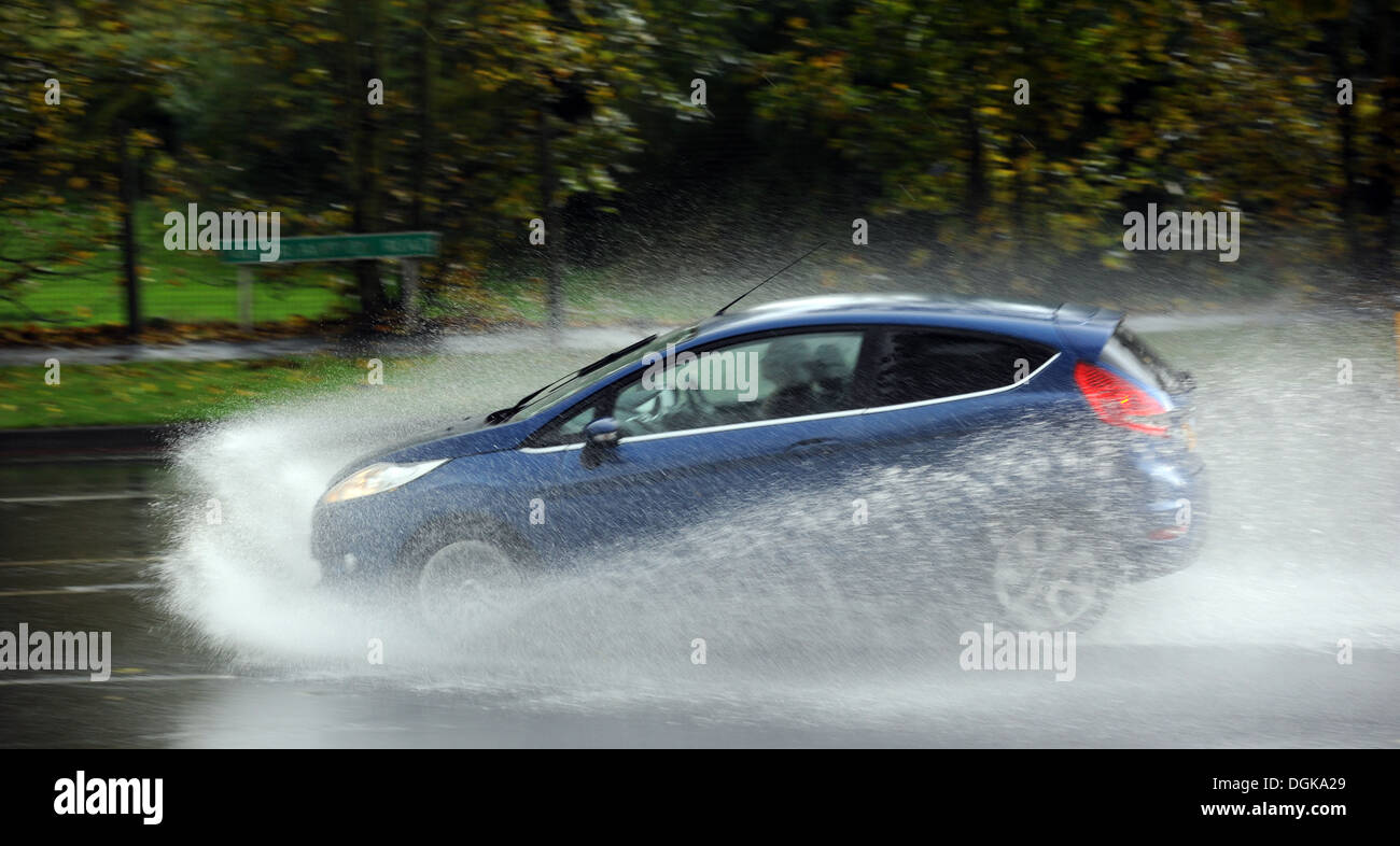 EIN PKW DURCH STARKREGEN SPRITZWASSER AUF EINER ÖFFENTLICHEN STRAßE RE WETTER STEHEN NASS SKID SCHLEUDERN WINTER AUTOFAHRER UK Stockfoto