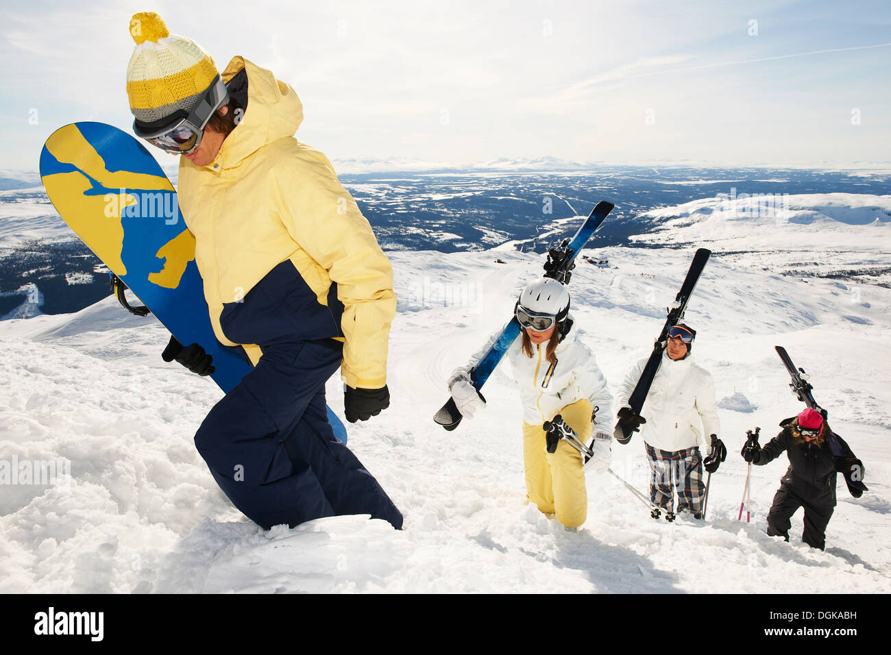 Snowboarder und Skifahrer tragen der Ausrüstung an die Spitze des Berges Stockfoto Snowboarder und Skifahrer tragen der Ausrüstung an die Spitze des Berges Stockfoto