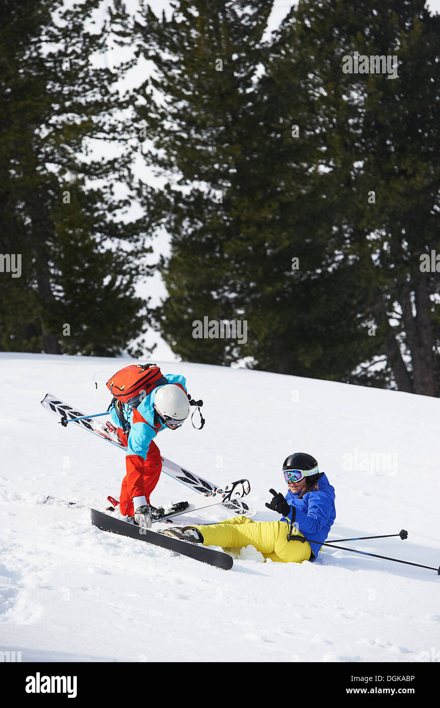 Skifahrer, die helfen, eine andere oben Stockfoto