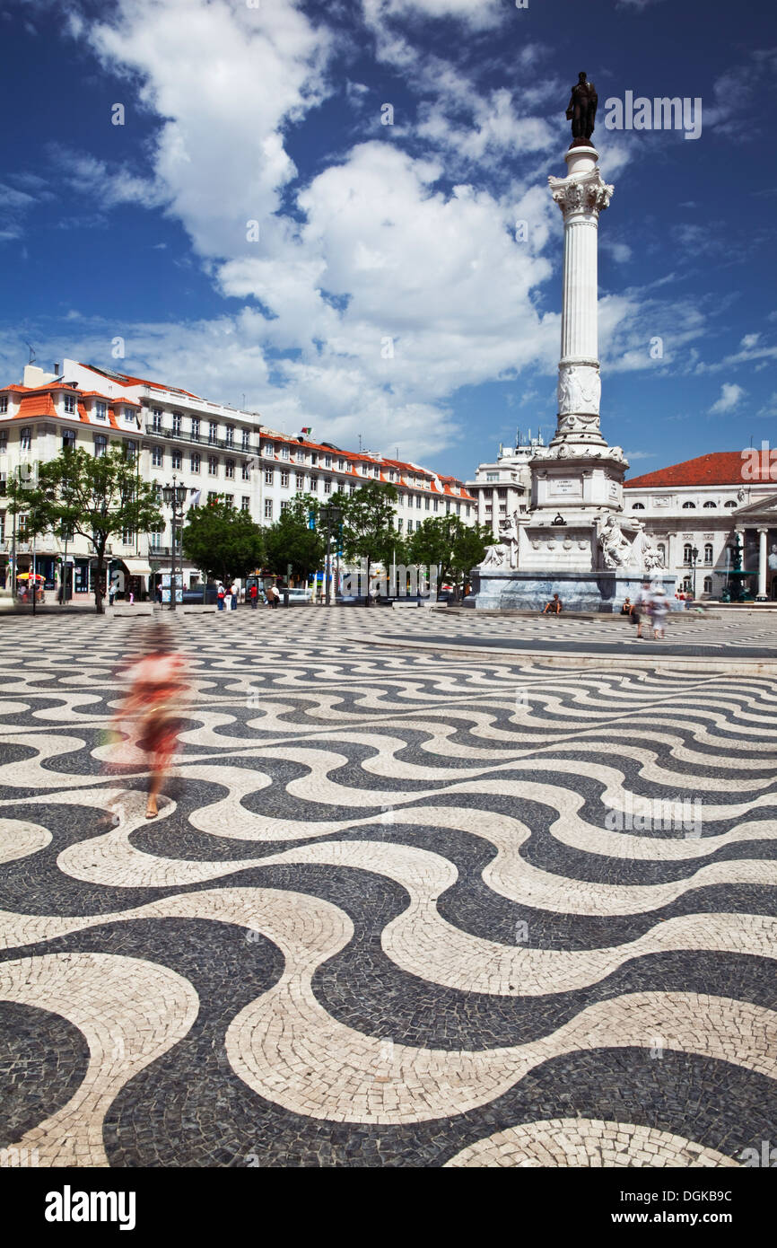 Frau im roten Kleid, die zu Fuß über Praça Dom Pedro IV oder Rossio-Platz. Stockfoto