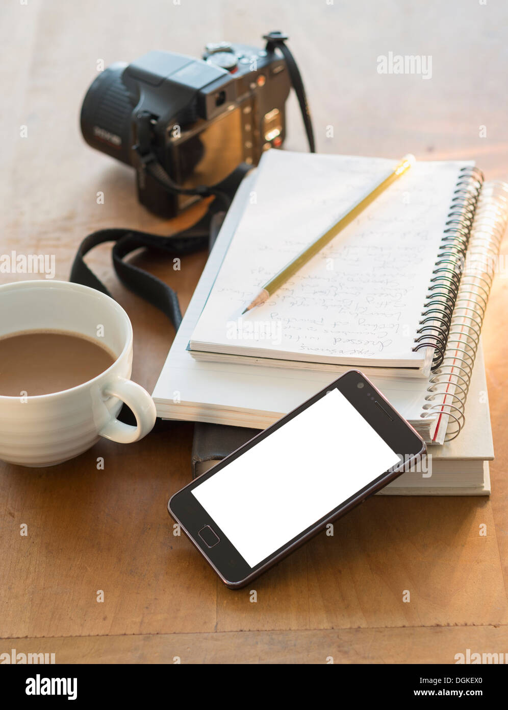 Studioaufnahme Notizblöcke, Smartphone, Kamera und Kaffee Stockfoto