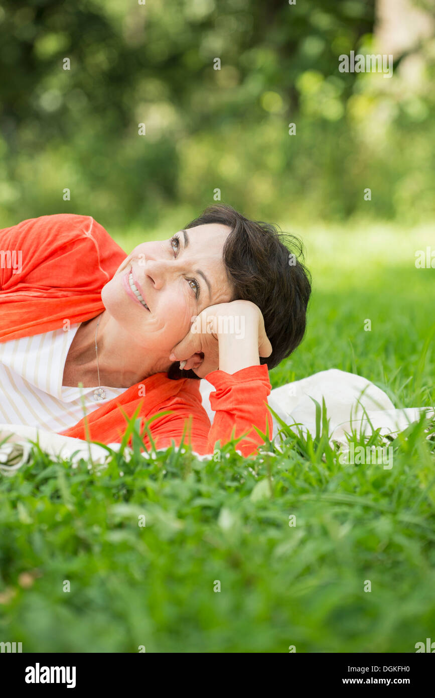 Reife Frau liegend auf dem Rasen Stockfoto