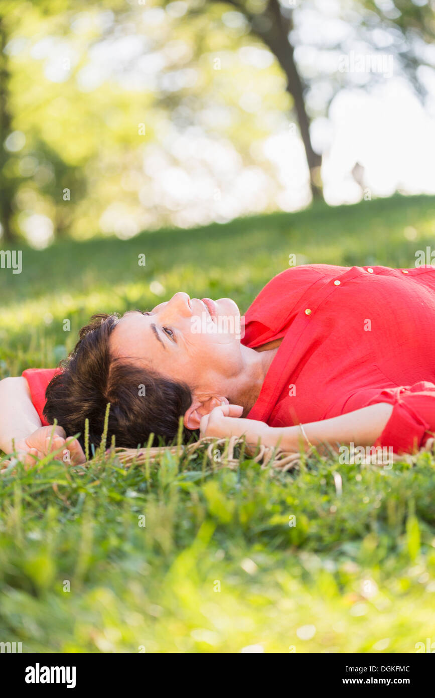 Reife Frau liegend auf dem Rasen Stockfoto