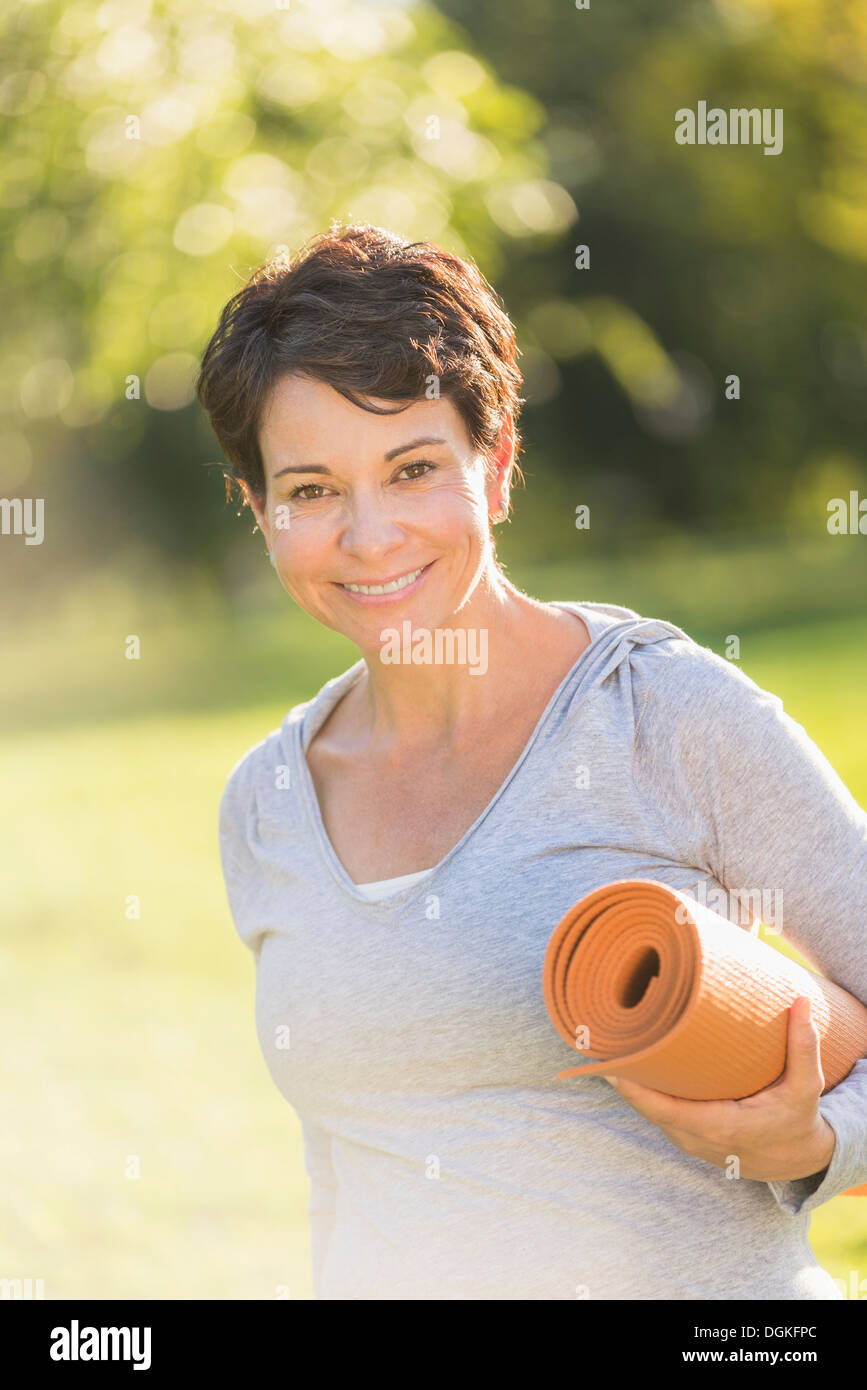 Reife Frau mit Yoga-Matte im freien Stockfoto