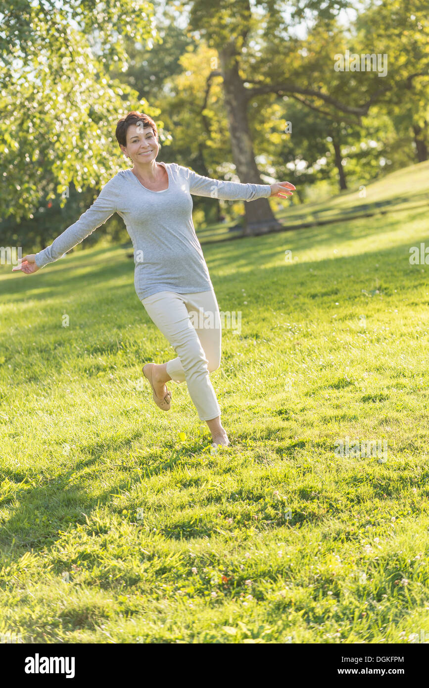 Reife Frau springen auf Rasen Stockfoto