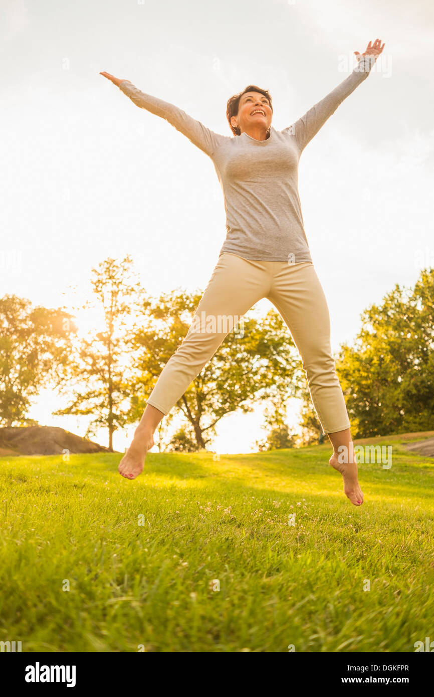 Reife Frau springen auf Rasen Stockfoto