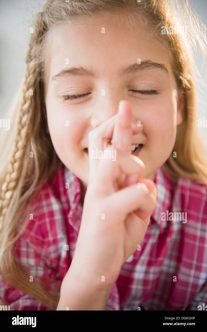 Porträt eines Mädchens gekreuzt (8-9) wollen mit Fingern Stockfoto