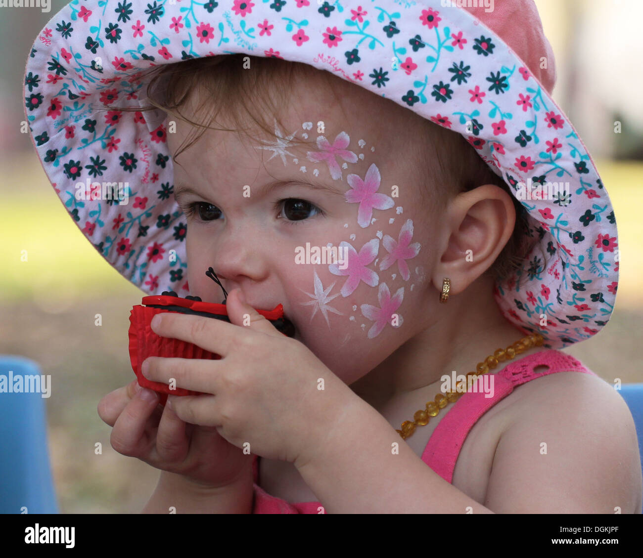 ein junges Mädchen genießen einen Schokoladen cupcake Stockfoto