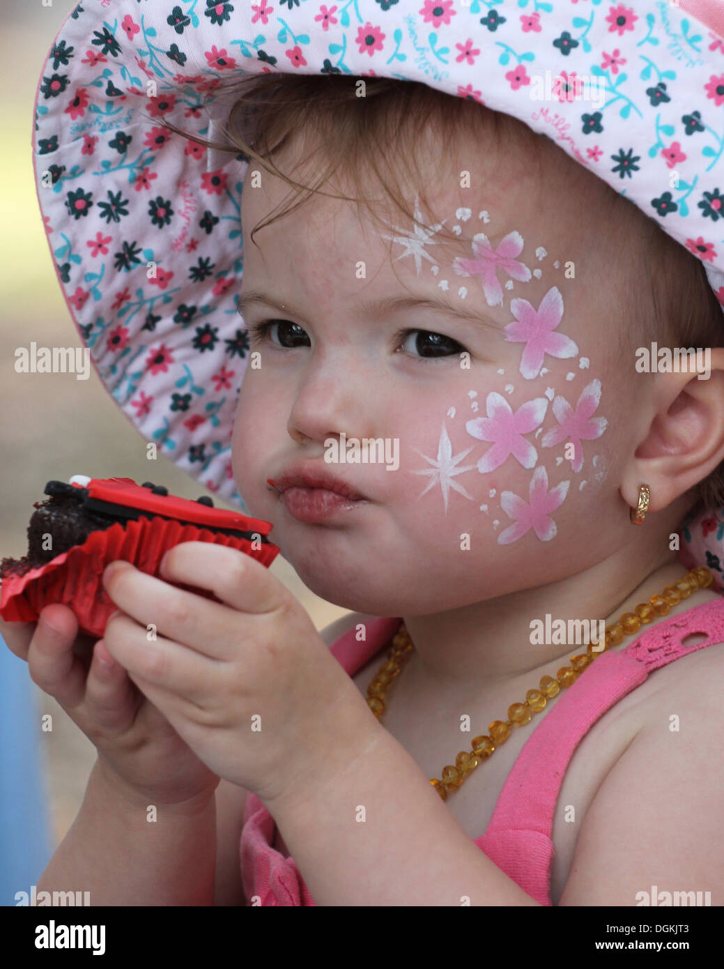 ein junges Mädchen genießen einen Schokoladen cupcake Stockfoto