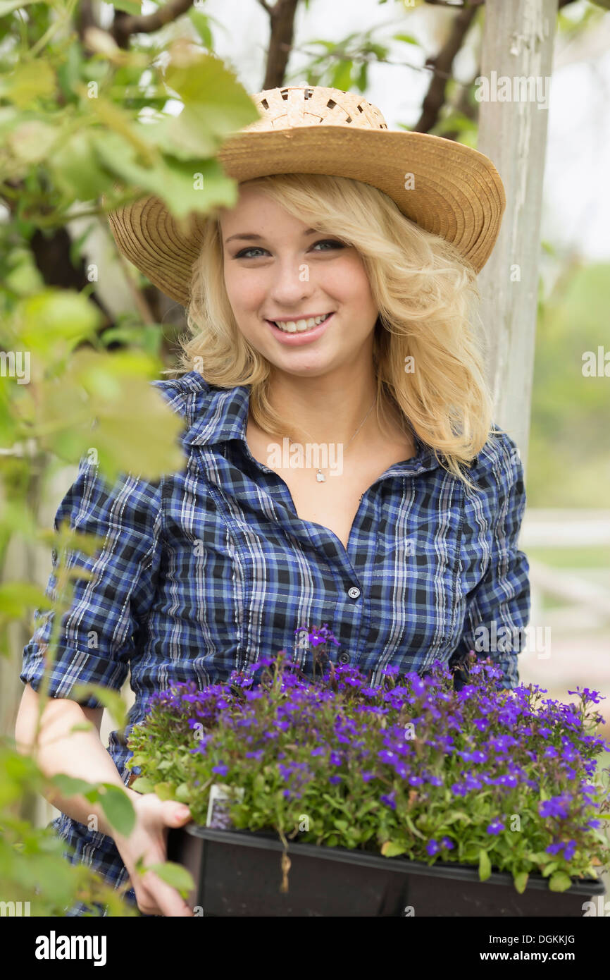 USA, New Jersey, alten Docht, Porträt der jungen Frau hält Topfpflanzen Blumen Stockfoto