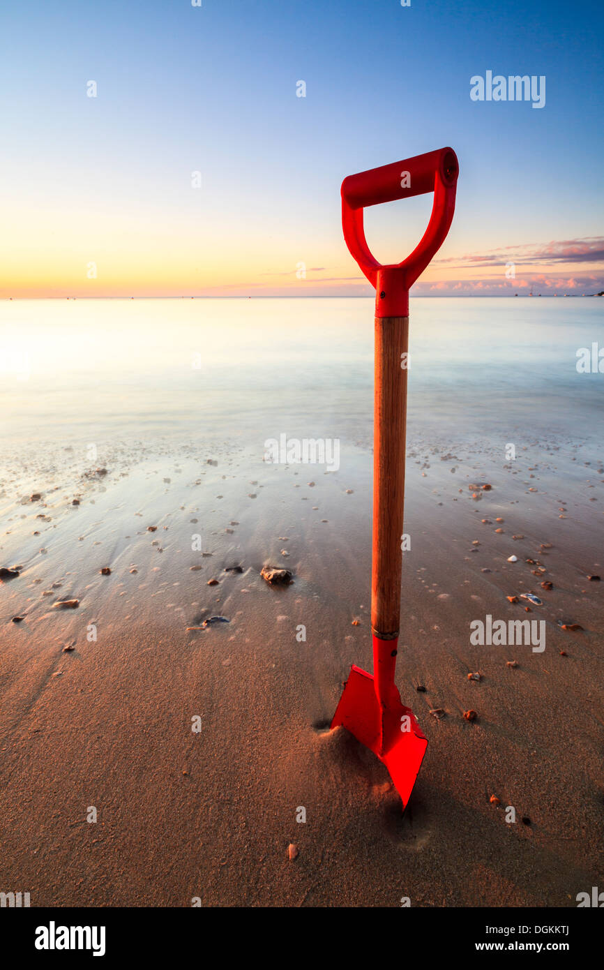 Spaten Sie in den Sand am Strand von Swanage an einem sonnigen Morgen. Stockfoto