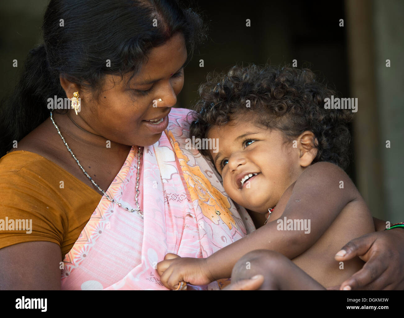 Junge indische Mutter ihre Tochter in einem indischen Dorf kuscheln. Andhra Pradesh, Indien Stockfoto