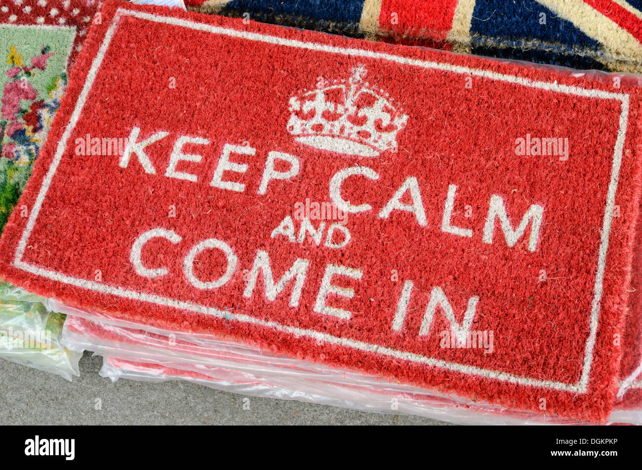 Der Slogan Keep Calm und kommen In auf eine Fußmatte vor einem Geschäft. Stockfoto