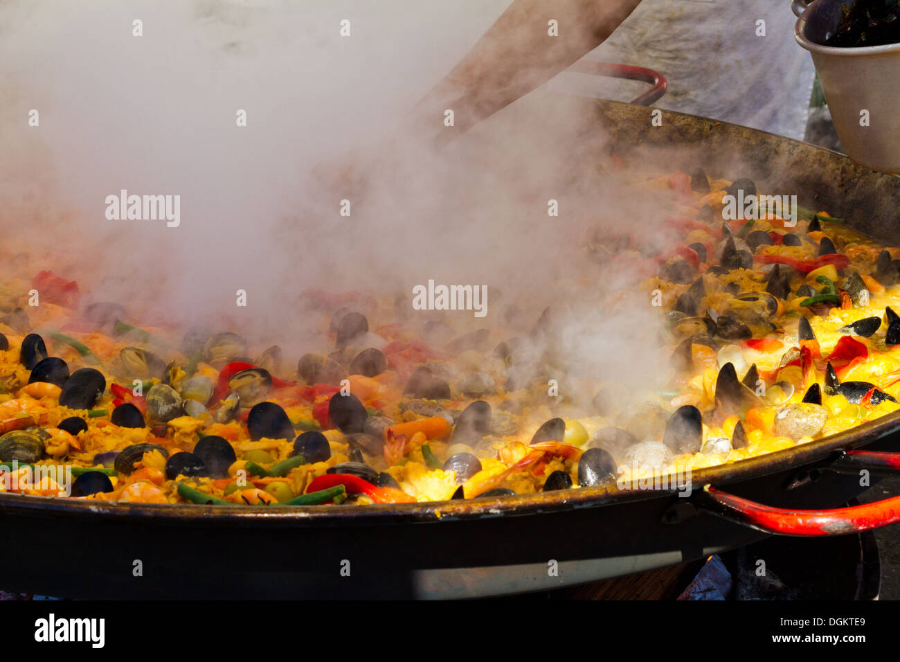Kochen Sie, tendenziell eine große Pfanne Paella Kochen über einem Holzfeuer auf einem Meeresfrüchte-Festival in Santa Barbara, Kalifornien Stockfoto